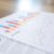 Bar and line graphs on printed business reports placed on a wooden desk.